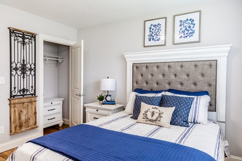 a bedroom with a bed with blue and white bedding and a nightstand with a lamp